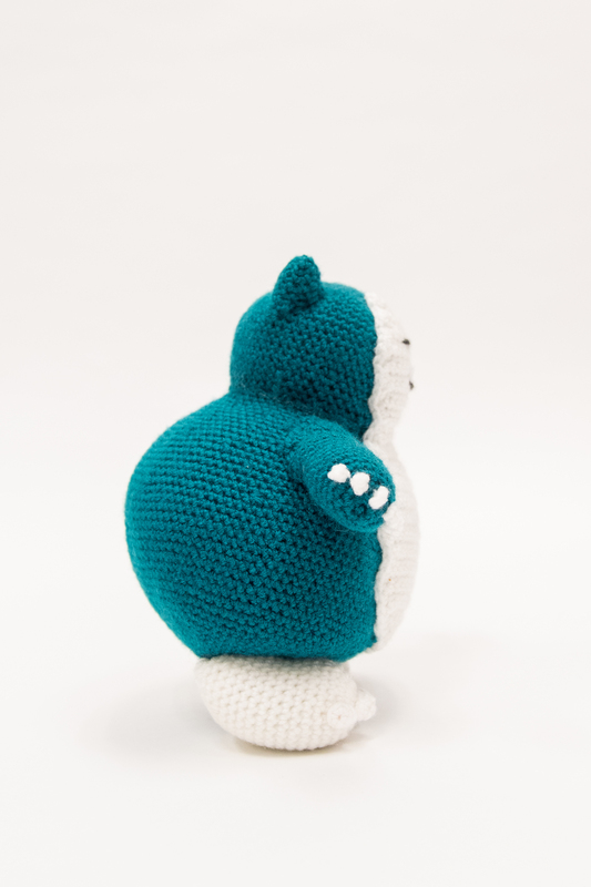 Image of a crocheted Snorlax from the side. 