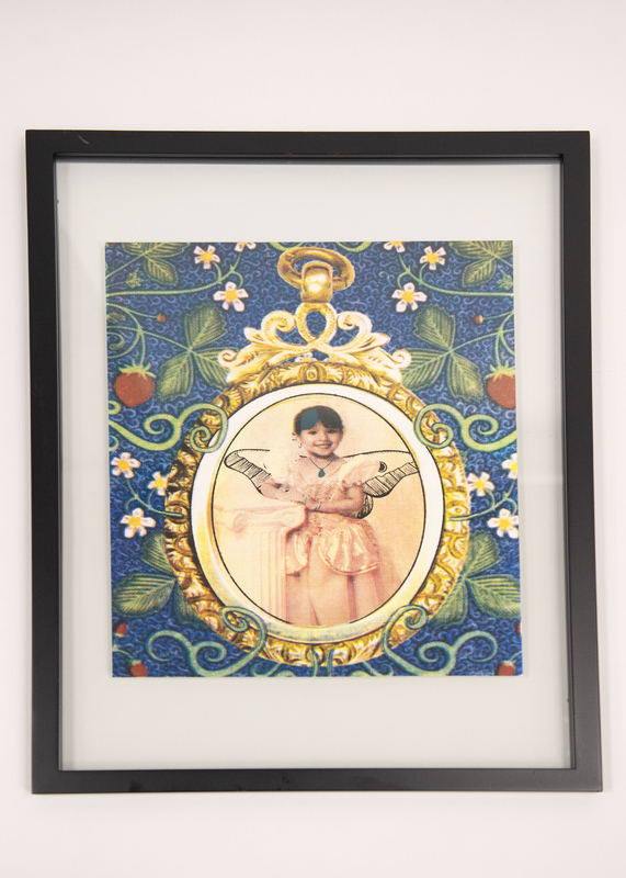 Image of a child in a gold photo frame surrounded by strawberry plants.