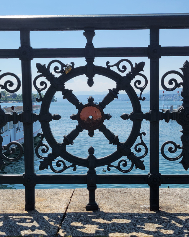 color photograph of an ornate railing over a large body of water