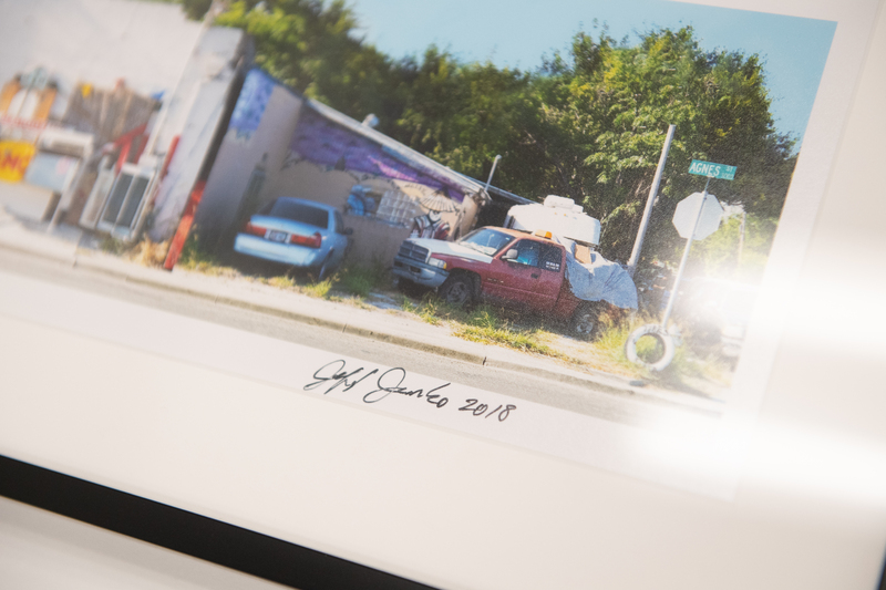 A close up image of a photograph of trucks with artist signature. 