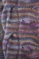 Close up detail of a knitted wrap in shades of purple