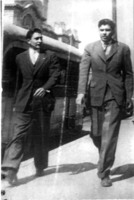 Brothers, Arturo and Rodolfo “Fito” Vasquez, Jr., walking on the streets of Mexico City, Mexico. Fito is wearing a glove over his wounded left hand. Black and white photograph. 
