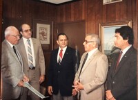 Arturo Vasquez with Mayor Luther Jones, holding proclamation in his hand, and Simon R. Ortiz, (light tan suit) Acting Director of MBDC of Corpus Christi, talking to Mayor Jones.